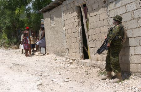 Un soldat des Forces Canadiennes effectue une fouille des maisons à Port-au-Prince.