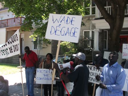 A banner reads "Wade Degage" ("Out with Wade") as protestors noisely chanted in front of the Senegalese Embassy in the Ottawa neighbourhood of Sandy Hill.